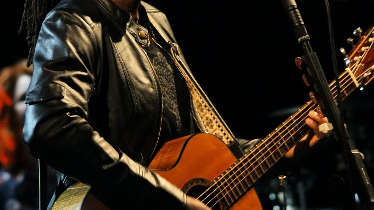 Tracy Chapman performing with guitar on stage in soft lighting
