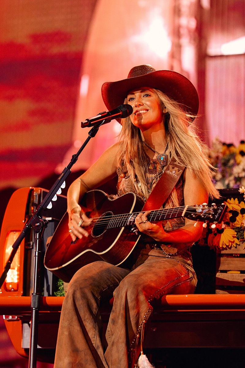 Lainey Wilson performing on stage at a country music concert