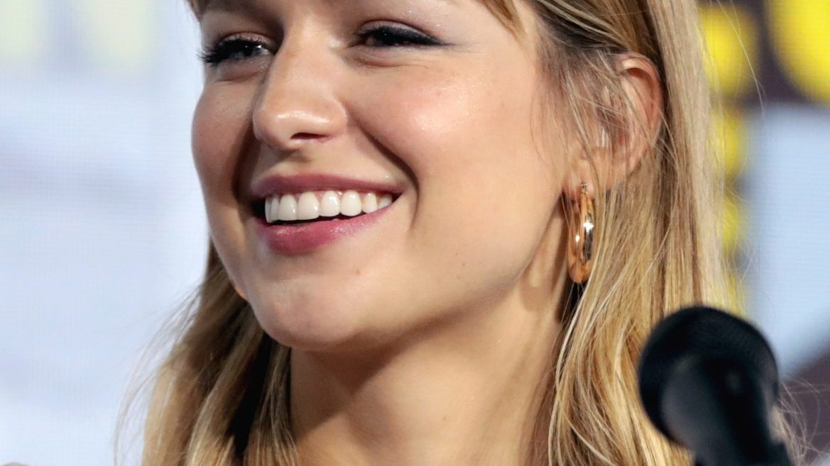 Melissa Benoist smiling at a television premiere in a red dress