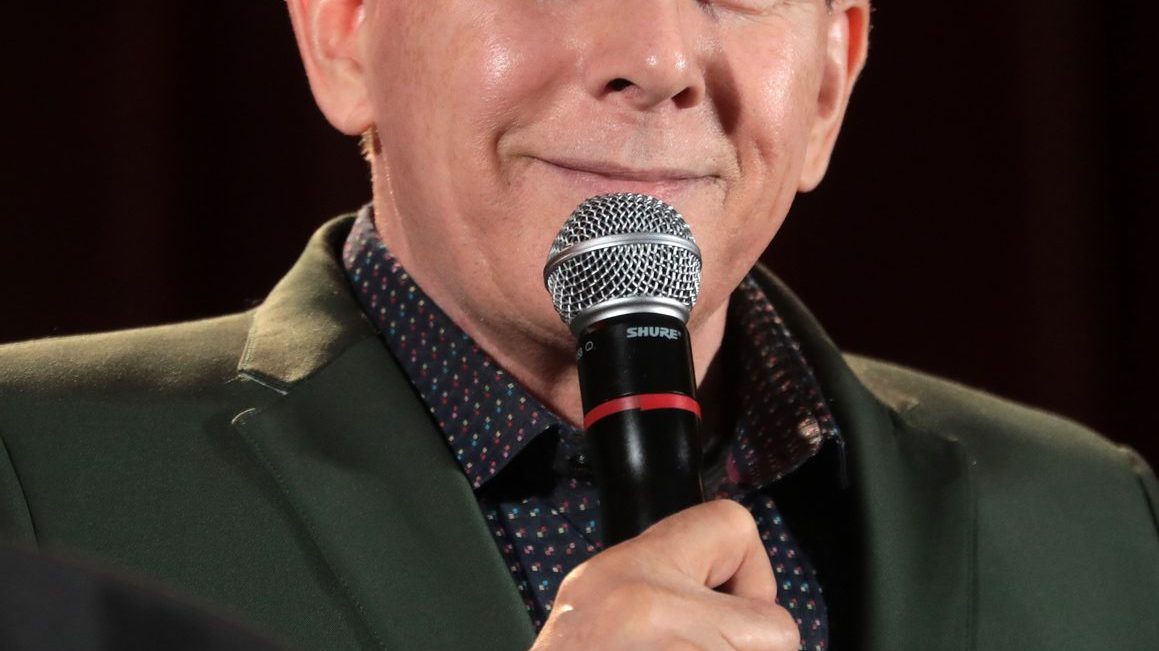 Paul Reubens as Pee-wee Herman in his iconic gray suit and red bow tie