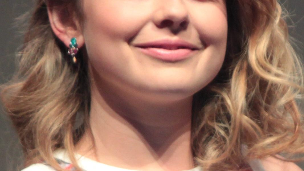 Rose McIver smiling at a television event in a floral dress