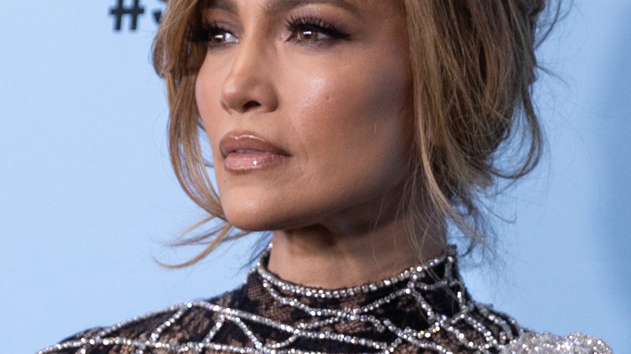 Jennifer Lopez smiling on the red carpet in a glamorous dress