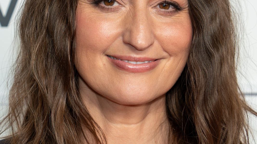 Sara Bareilles smiling on the red carpet in an elegant gown