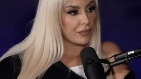 Tana Mongeau posing at a red carpet event in a stylish outfit